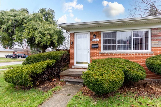 doorway to property featuring brick siding