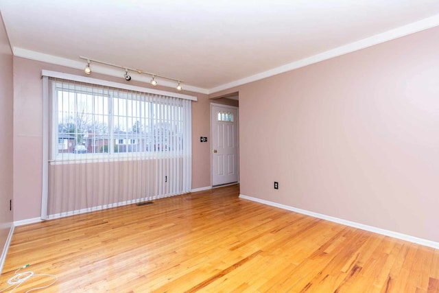unfurnished room with light wood-style flooring, baseboards, rail lighting, and visible vents