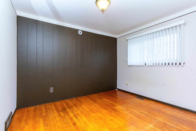 spare room with wood finished floors and visible vents