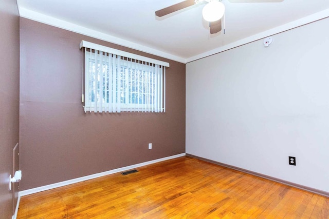 spare room featuring light wood-style flooring, baseboards, a ceiling fan, and visible vents