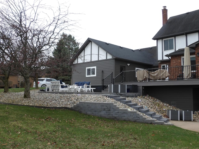rear view of property with a yard, stairway, a deck, and a patio area