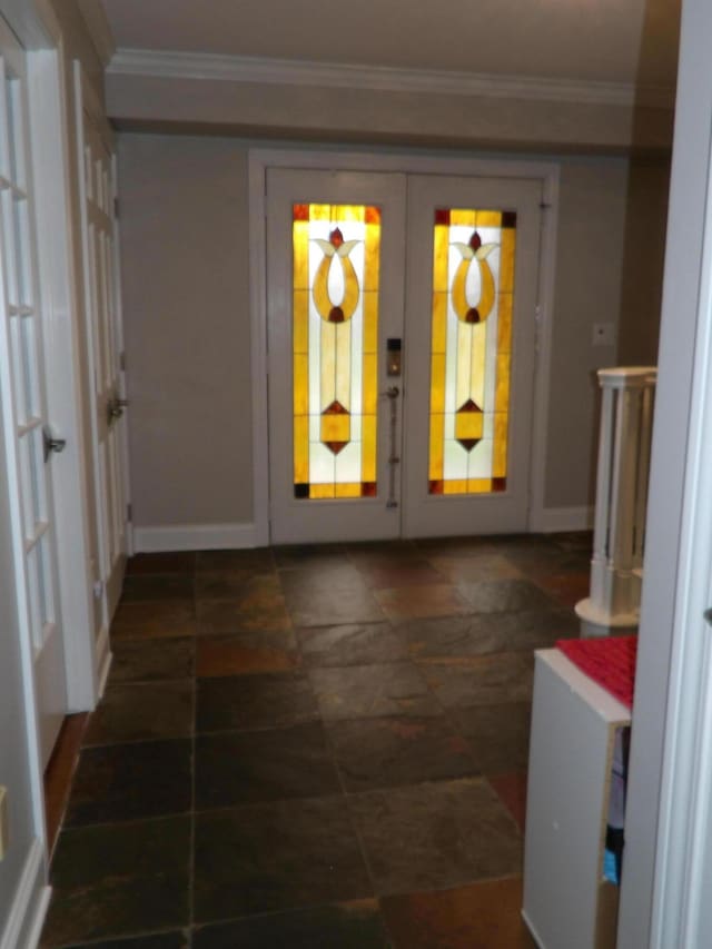 interior space with stone finish flooring, french doors, baseboards, and ornamental molding