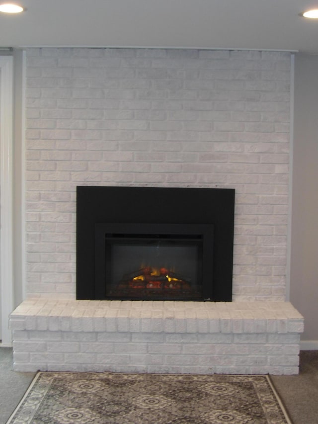 details featuring carpet floors, baseboards, recessed lighting, and a brick fireplace