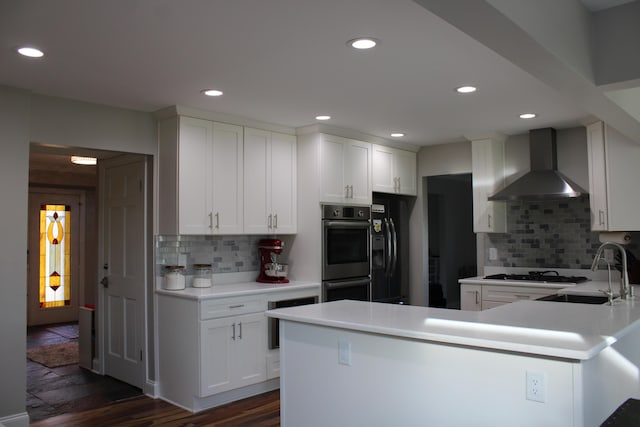 kitchen with gas cooktop, stainless steel double oven, wall chimney exhaust hood, decorative backsplash, and a sink