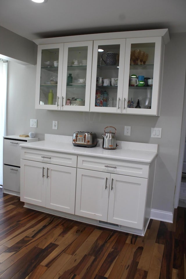 bar with visible vents, baseboards, and dark wood-style floors