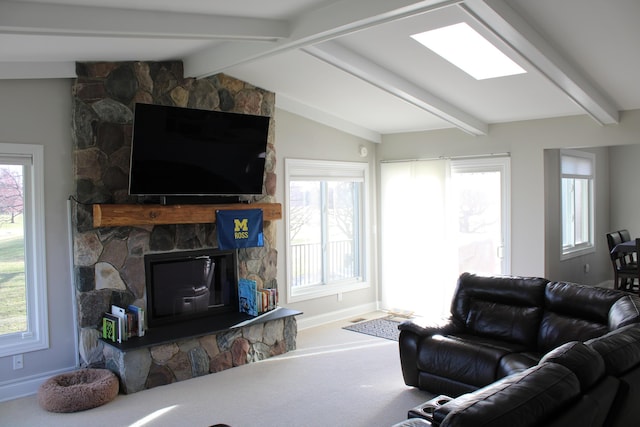 living room featuring a stone fireplace, baseboards, vaulted ceiling with beams, and carpet