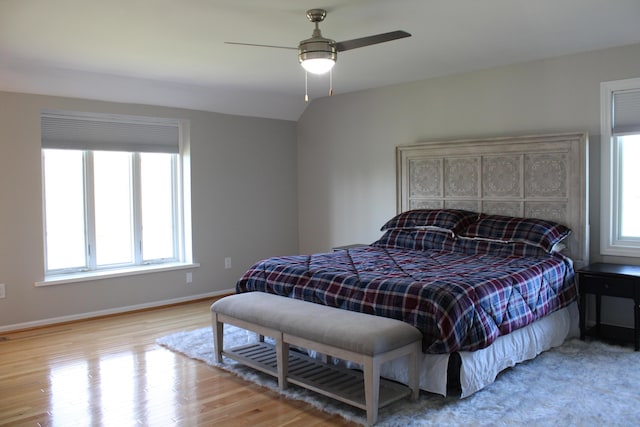 bedroom featuring baseboards, light wood finished floors, and ceiling fan