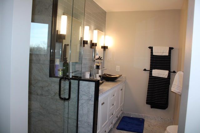 bathroom featuring toilet, a shower stall, and vanity