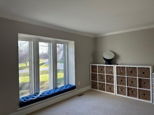 empty room featuring crown molding, visible vents, baseboards, and carpet flooring