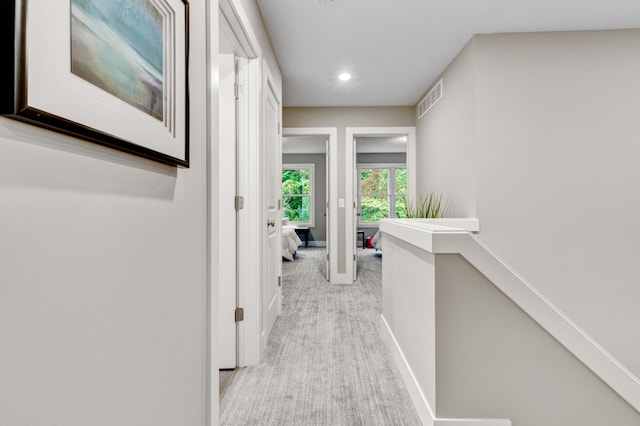 corridor featuring light colored carpet, visible vents, recessed lighting, an upstairs landing, and baseboards