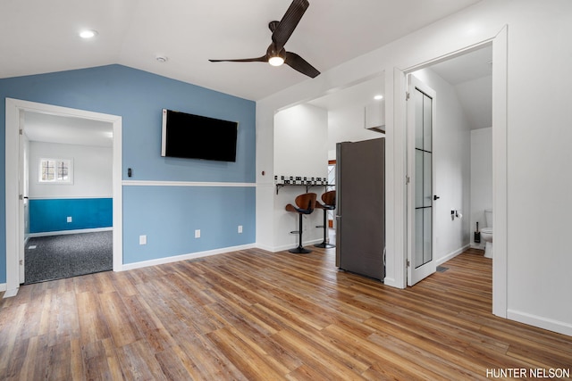 175 Cora Ave, Muskegon, MI 49445 - unfurnished living room with wood finished floors, baseboards, a ceiling fan, and vaulted ceiling
