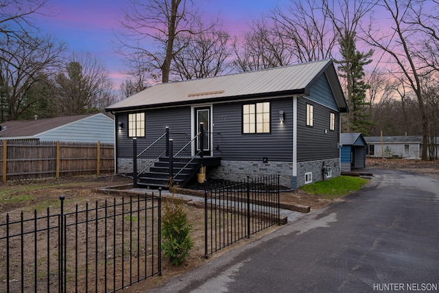 175 Cora Ave, Muskegon, MI 49445 - view of front of home featuring metal roof, an outdoor structure, and a fenced front yard
