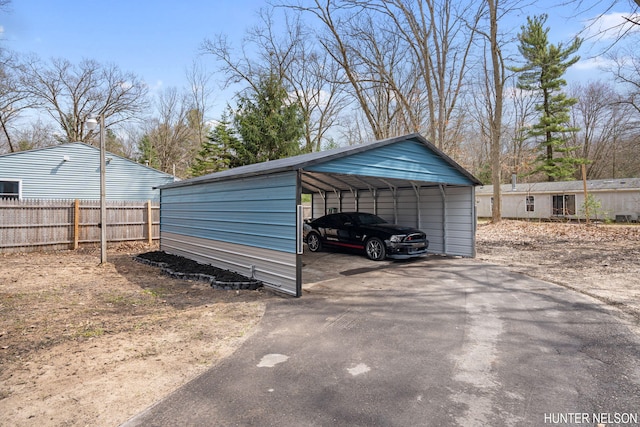 175 Cora Ave, Muskegon, MI 49445 - view of parking / parking lot with aphalt driveway, a detached carport, and fence