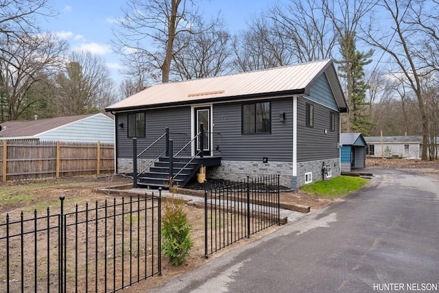 175 Cora Ave, Muskegon, MI 49445 - view of front of property featuring a detached garage, an outdoor structure, metal roof, and a fenced front yard