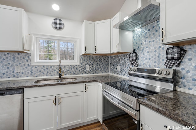 175 Cora Ave, Muskegon, MI 49445 - kitchen featuring wall chimney range hood, white cabinetry, appliances with stainless steel finishes, a sink, and wood finished floors