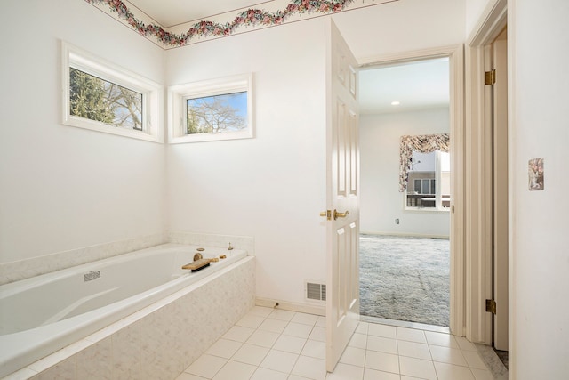 bathroom with a garden tub, tile patterned floors, and visible vents