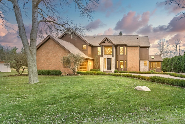 view of front of home with a front lawn, stone siding, brick siding, and a chimney