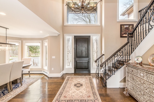 foyer entrance with an inviting chandelier, stairs, and dark wood-type flooring