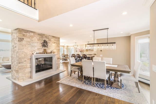 dining area featuring a baseboard heating unit, recessed lighting, ornamental molding, and wood finished floors