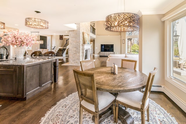 dining space with dark wood-style flooring, a large fireplace, recessed lighting, and a notable chandelier