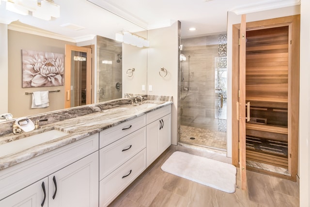 full bath with double vanity, ornamental molding, a stall shower, and a sink
