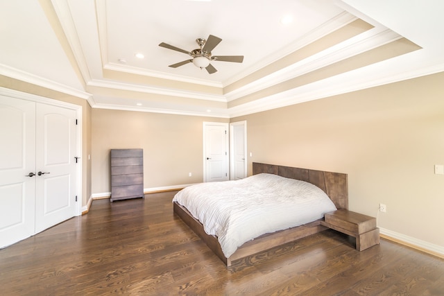 bedroom with crown molding, a tray ceiling, baseboards, recessed lighting, and wood finished floors