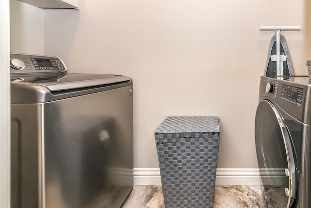 clothes washing area with separate washer and dryer and laundry area