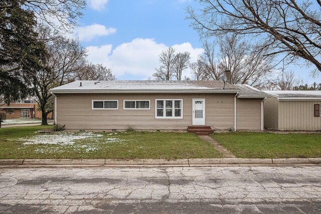 back of property with entry steps and a yard