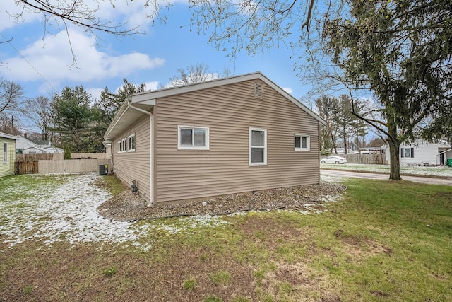 view of side of property with a yard, fence, and central AC