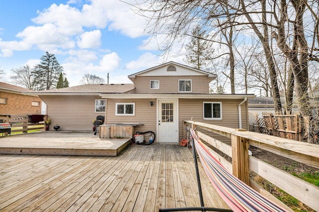 back of property featuring a deck and fence