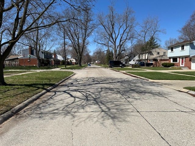 view of street featuring a residential view and curbs