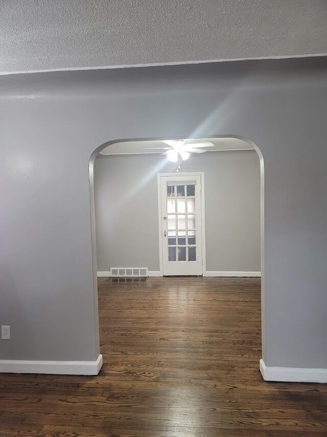 18639 Appoline St, Detroit, MI 48235 - spare room featuring arched walkways, baseboards, wood finished floors, and a textured ceiling