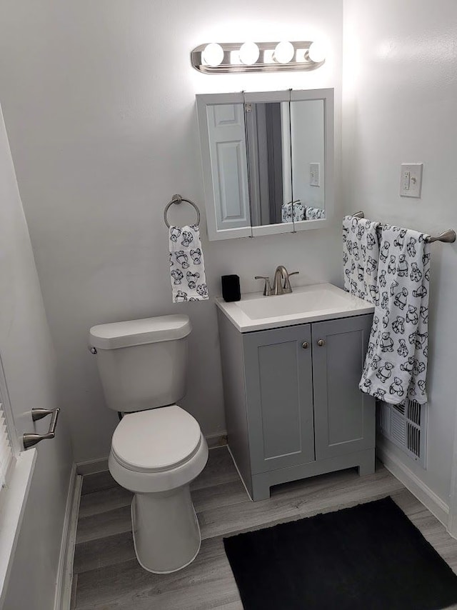18639 Appoline St, Detroit, MI 48235 - half bathroom featuring vanity, toilet, wood finished floors, and baseboards