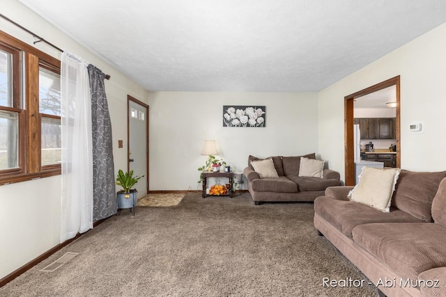 carpeted living area with baseboards and visible vents