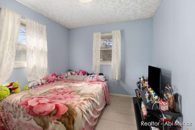 bedroom featuring tile patterned floors and baseboards