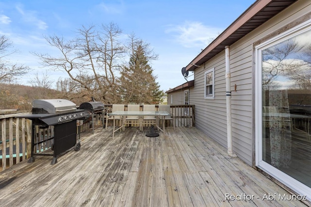 wooden deck with area for grilling and outdoor dining space