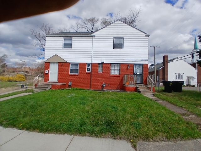 16128 Dexter Ave, Detroit, MI 48221 - view of front of home with brick siding, a front yard, and fence