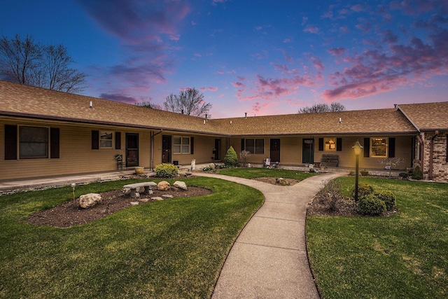 single story home with a front yard, a porch, and a shingled roof