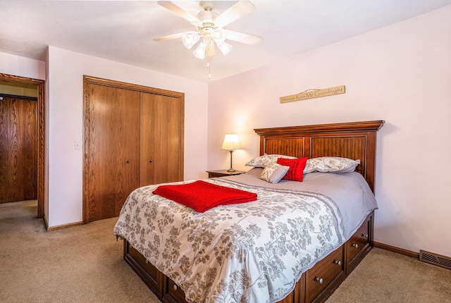 bedroom featuring a closet, baseboards, a ceiling fan, visible vents, and light colored carpet