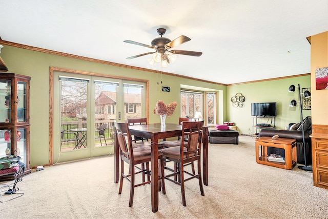 dining room with light colored carpet, ceiling fan, and ornamental molding