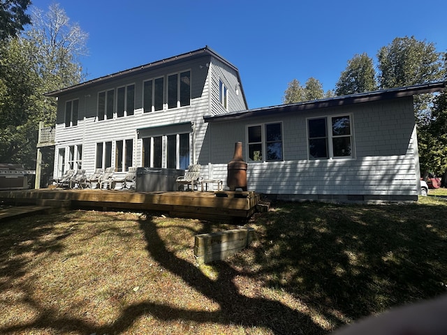rear view of house featuring a deck, crawl space, and a lawn