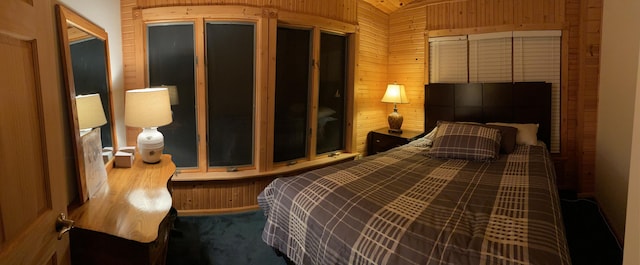 bedroom featuring wood walls and carpet