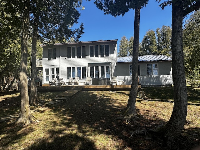rear view of property with a wooden deck and a standing seam roof