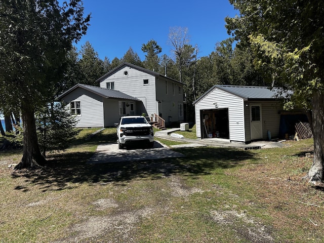 exterior space with entry steps, an outdoor structure, a yard, and metal roof