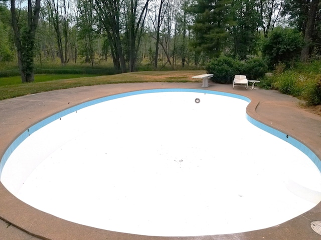 4717 Mohican Ln, Okemos, MI 48864 - view of swimming pool with a diving board, a patio area, and an empty pool