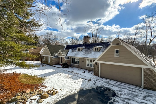 4717 Mohican Ln, Okemos, MI 48864 - view of front facade featuring brick siding, a chimney, and a garage