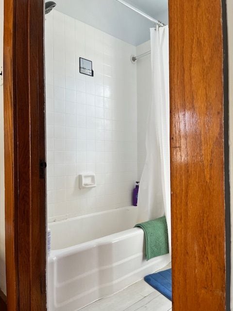 bathroom with shower / bath combo and wood finished floors
