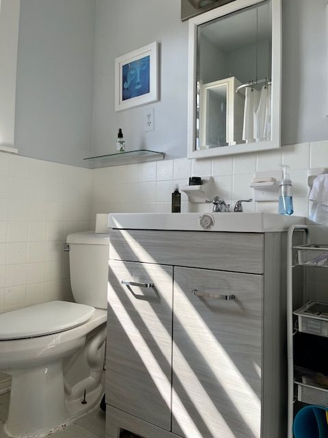 bathroom featuring tile walls, toilet, and vanity