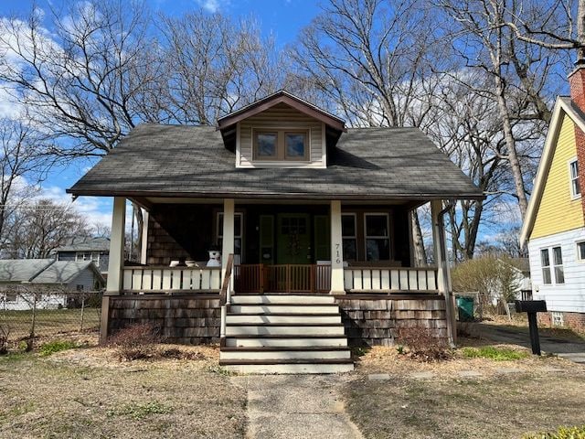 view of front of house with a porch, stairs, and fence