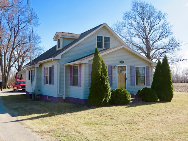 view of front of home with central air condition unit and a front yard
